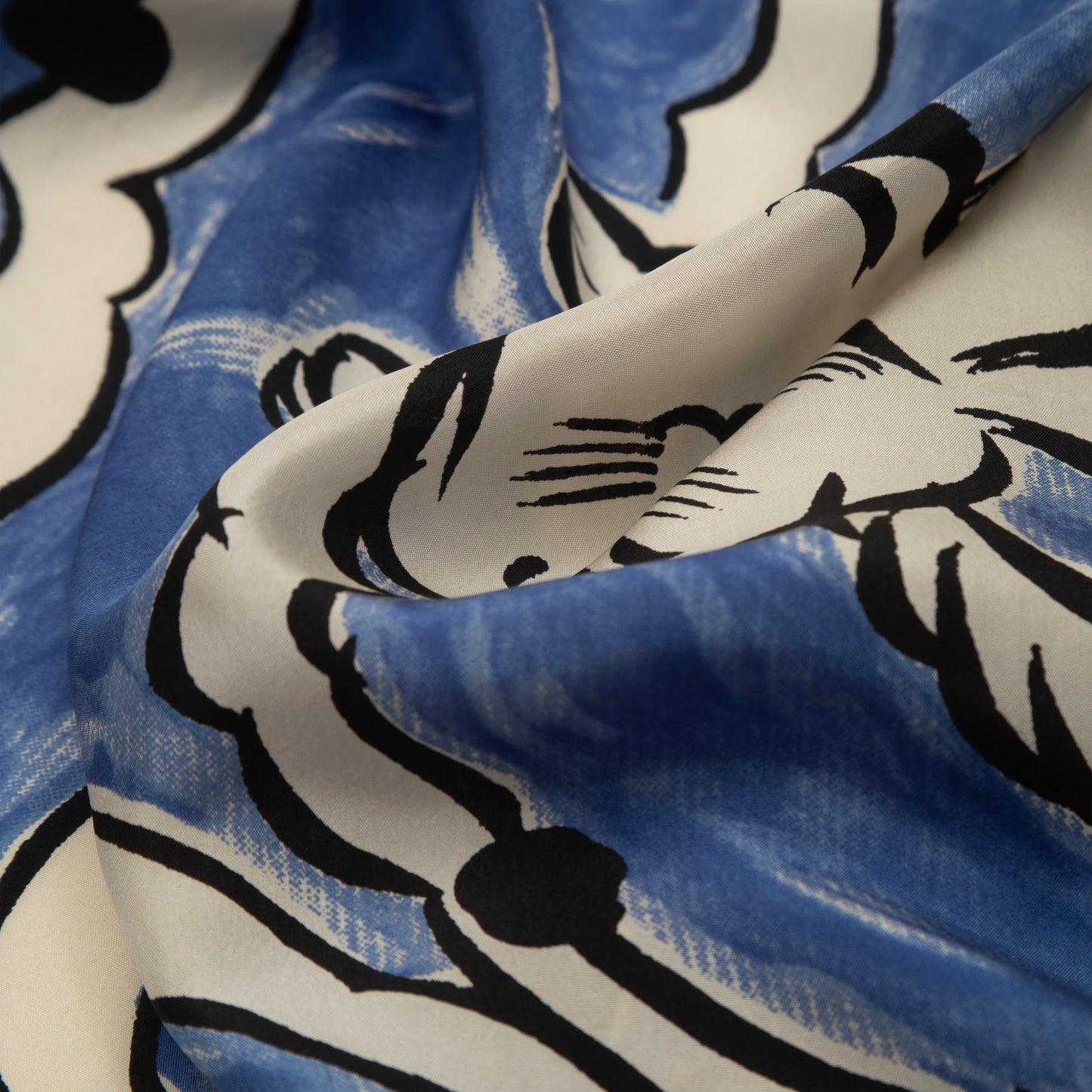close up detail of the Hero David Bowie scarf showing screen printed design of black outlined, white flying rabbits on electric blue background with a soft lustrous sheen