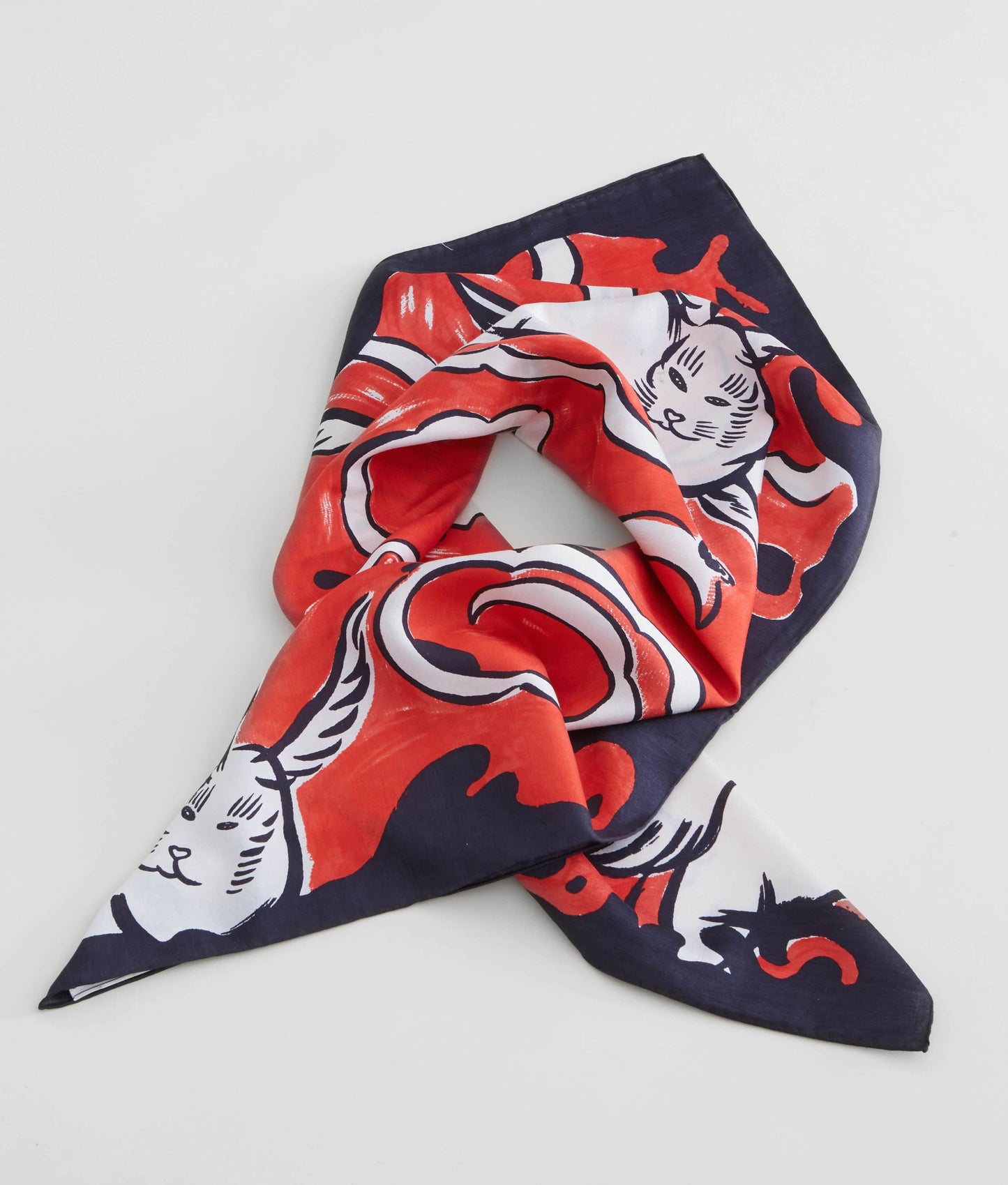 A luxury silk scarf designed for David Bowie Is exhibition featuring red, black and cream "Hero" design. The print showcases an artistic composition inspired by Bowie's Ziggy Stardust era, finished with signature hand-rolled hem and a soft lustrous sheen. 
